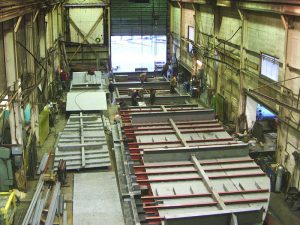 Flat section fabrications stacked on one another in main shop.